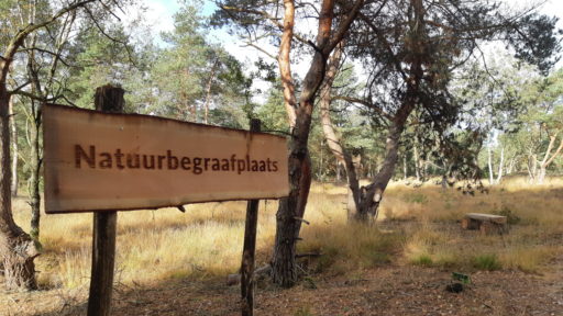 Een bord van natuurbegraafplaats in een natuurlijke omgeving waar natuurbegraafplaatsen zijn.
